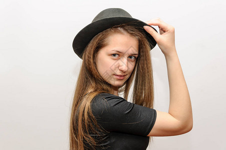 年轻女孩用白色工作室背景戴帽图片