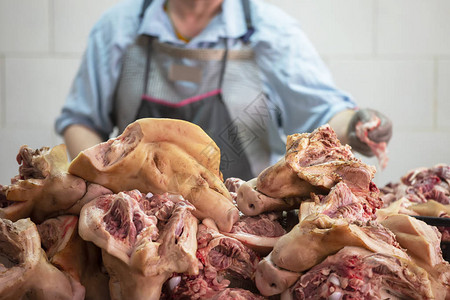 屠宰场猪头被切在屠夫的背图片