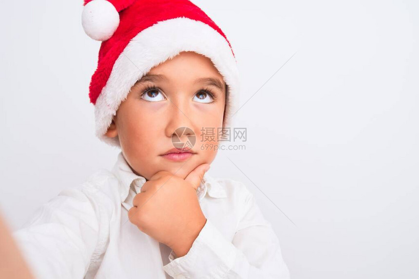 戴着圣诞帽的漂亮男孩在孤立的白色上自拍图片