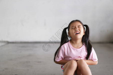 亚洲儿童可爱或小女孩坐在肚子痛图片