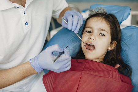 可爱的小女孩牙痛在儿科牙医处做牙图片