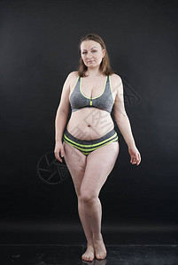加大码的女人以妊娠纹和脂肪团的头发展示她的身体图片