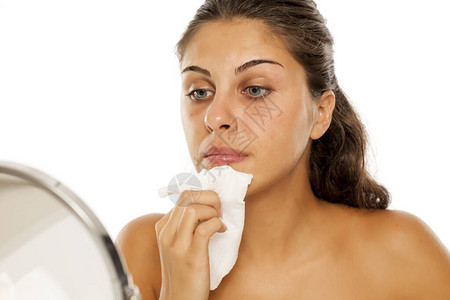 一个用湿纸巾擦脸的年轻女子的肖像背景图片