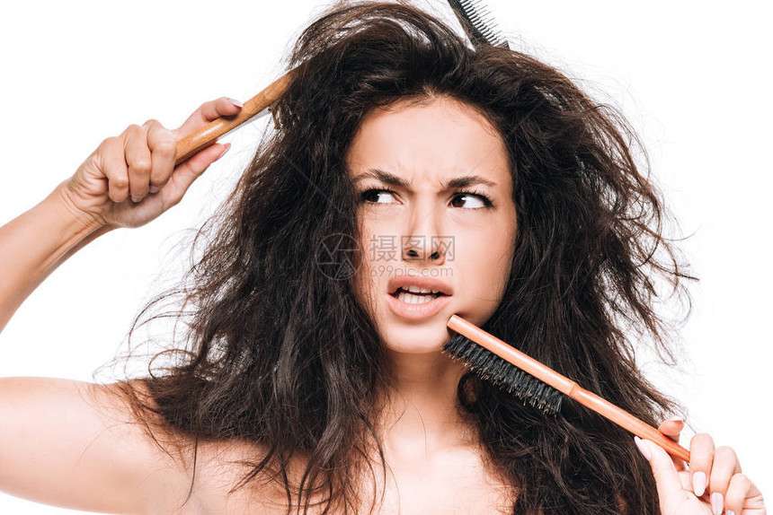 深褐色的困惑黑发女人梳子长着卷曲不整洁的头发图片