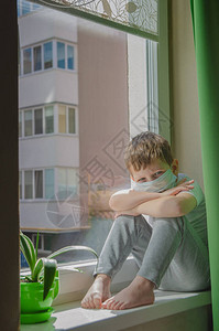 一个孩子坐在窗台上渴望图片