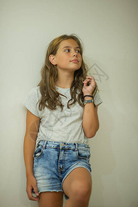 穿着灰色T恤和牛仔裤的女孩一个时尚的年轻漂亮女孩的肖像图片