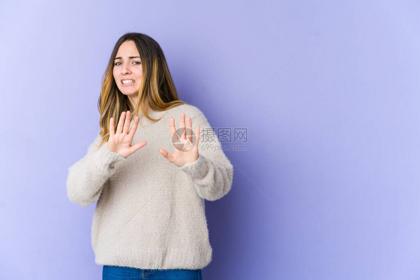 在紫色背景中被孤立的年轻高加索妇女拒绝某人表现出令人厌恶的姿态图片