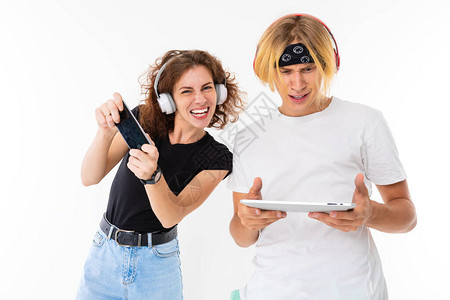 带移动电话的妇女和带数字平板电脑的男人在白色背景下用耳图片