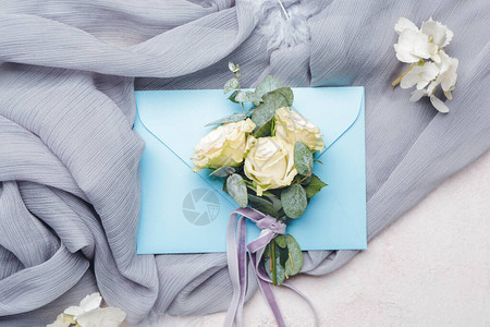 美丽的婚礼花束与白色背景上的信封图片
