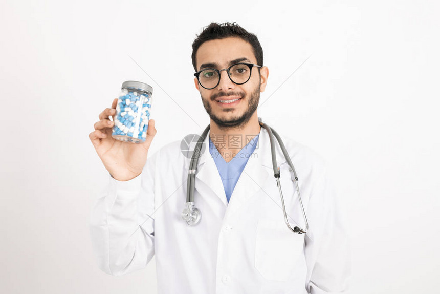 身穿白大褂的年轻成功医生在向您推荐新药时图片