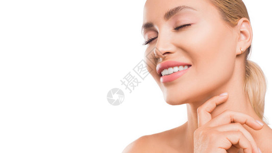 微笑的女人触摸着她完美的皮肤脸部皮肤护理概念图片