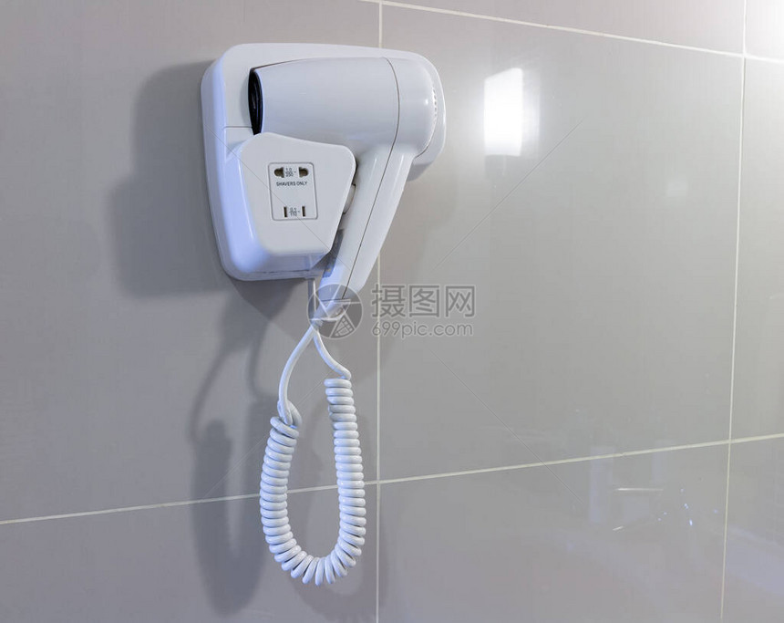 浴室墙上的吹风机用于淋浴后吹干头发图片