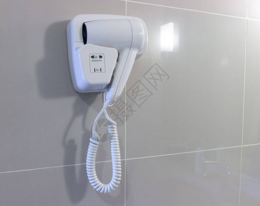 浴室墙上的吹风机用于淋浴后吹干头发图片