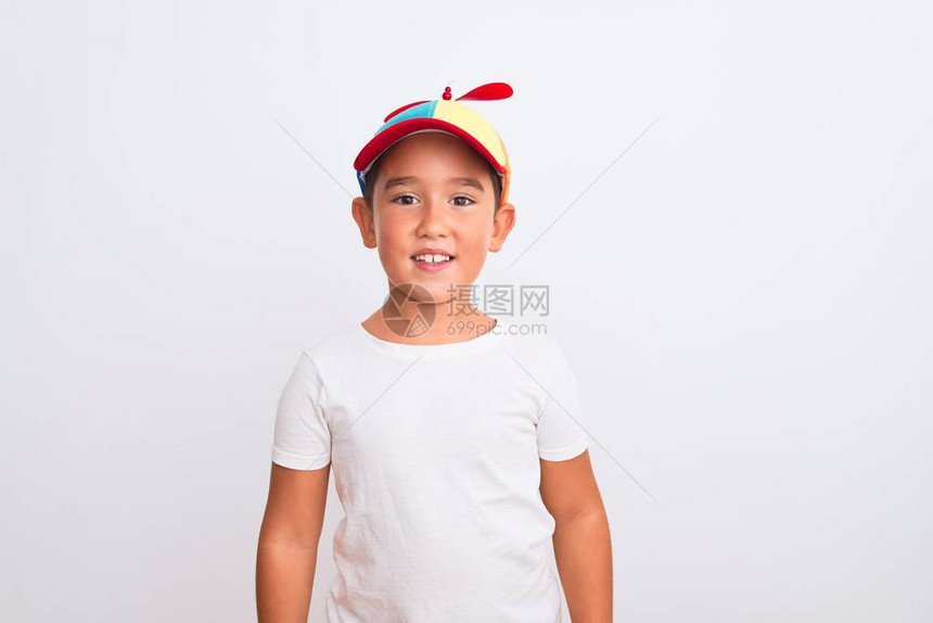 漂亮的男孩戴着满是花哨的帽子螺旋桨在孤立的白色背景上面带快乐和凉爽的笑图片