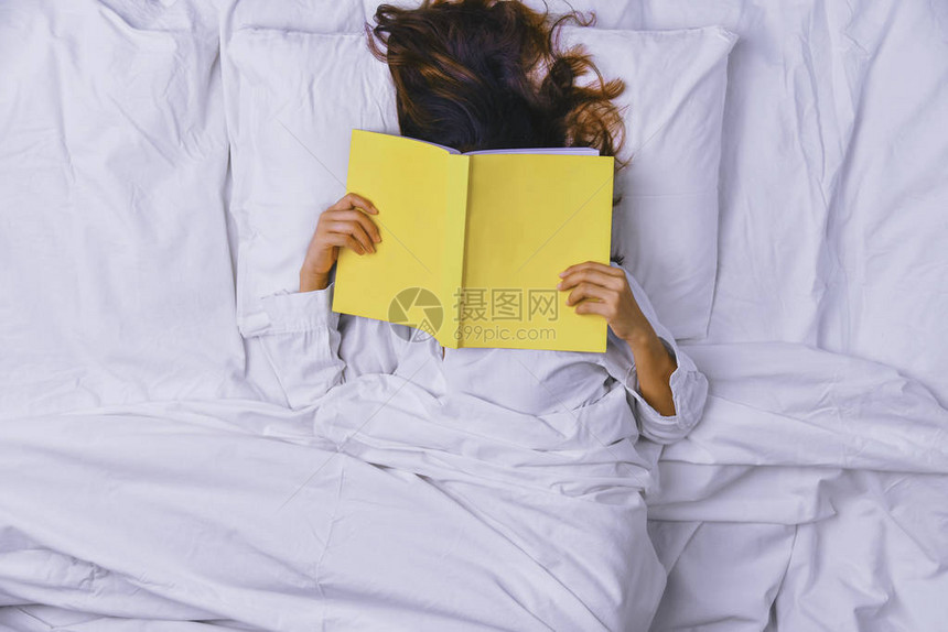 睡在床上的少妇躺在床上睡得很好的年轻女子的顶视图在床上看书和睡觉的女孩睡觉放松图片