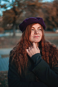 秋天公园戴帽子的红发女人的肖像图片