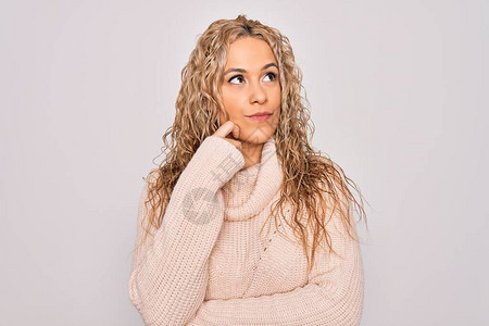 年轻漂亮的金发女郎穿着休闲毛衣站在孤立的白色背景上图片