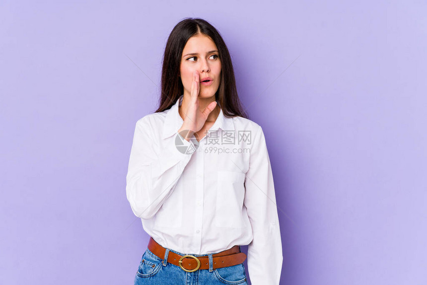 在紫色背景中被孤立的年轻高加索妇女正在说一个秘密的热播客新闻图片