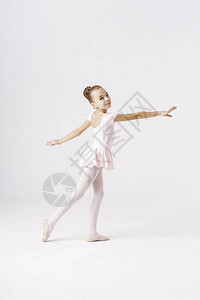 精致的女孩芭蕾舞女演员站在工作室的白色背景上的芭蕾舞姿势种图片