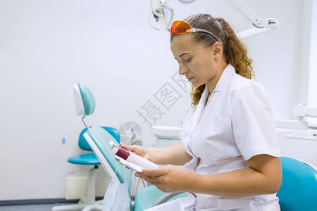 重度女牙医生阅读医学笔记牙科办公图片