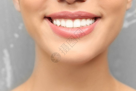灰色背景中牙齿健康的年轻女特写图片