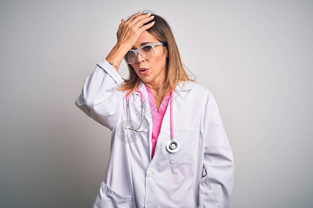 中年美女医生在孤立的白色背景上戴着粉色听诊器图片