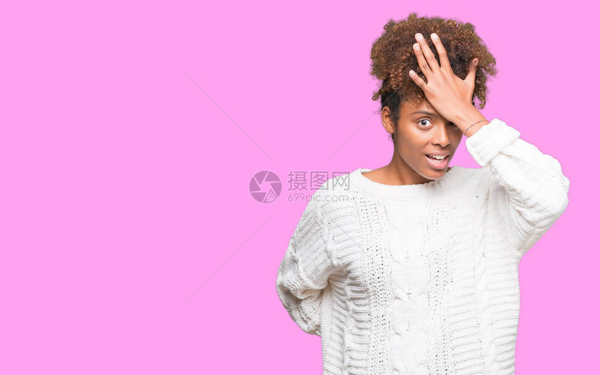 美丽的年轻非洲裔美国女人穿着冬季毛衣在孤立的背景下惊讶地用手捂着头图片