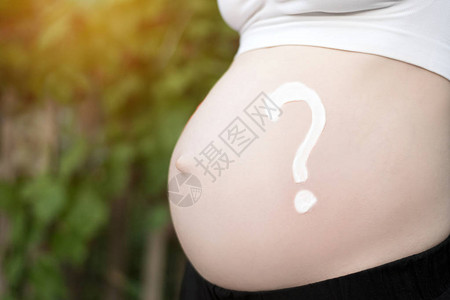 怀孕女肚子上的问题标记怀孕概念近距图片