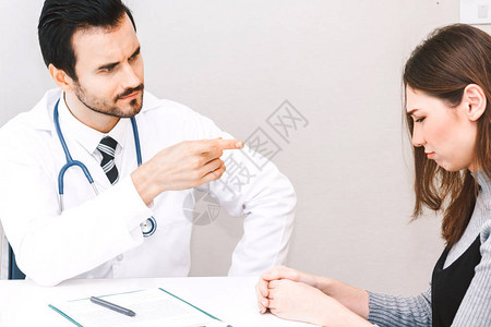 医生和女病人在医院的医生桌上就医图片