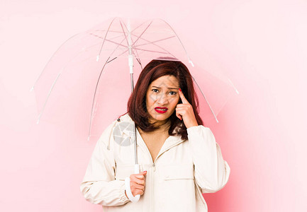 中年时身着雨伞的拉丁裔女与食人者表现出失望的姿态图片