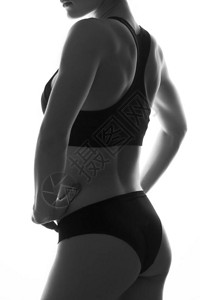 感苗条的女人身体与哑铃腹部肌肉发达运动服在白色上隔图片