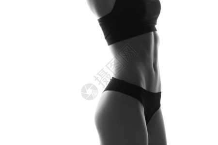 感苗条的女人身体与哑铃腹部肌肉发达运动服在白色上隔图片