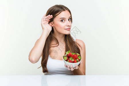 年轻caucasian女人拿着草莓碗图片