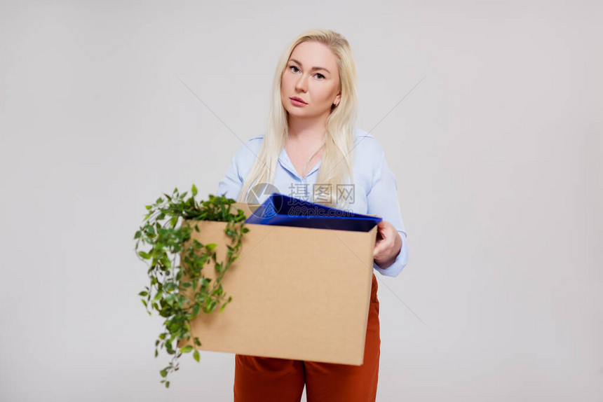 被解雇后不开心的女商人拿着纸板箱的肖像图片