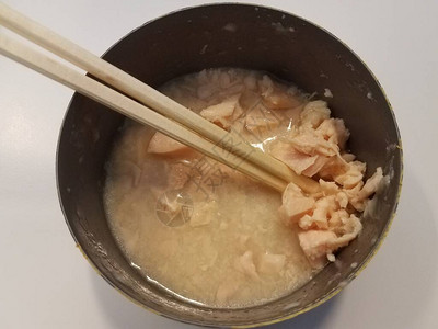 用筷子在肉汤中打开罐装白肉鸡罐头图片
