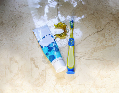 儿童牙膏牙刷和牙盘放在浴室窗边口腔护背景图片