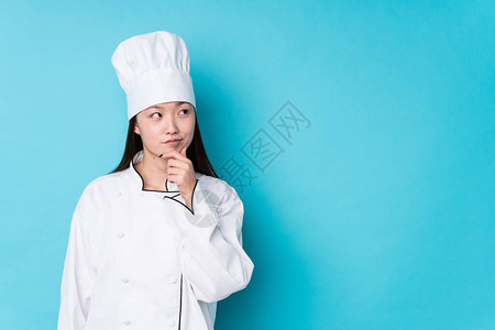 年轻的厨师女厨师以怀疑和怀疑的表情孤图片