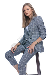 身穿蓝格式西装在白色背景上摆姿势和孤立坐着的自信女图片