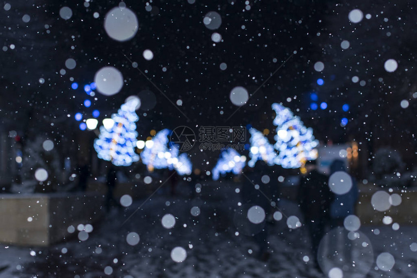 夜晚的节日街道灯光在下雪圣诞节和背景以及美丽的bokeh图片