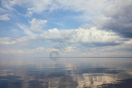 平静的池塘和浅蓝色的天空白云背景图片
