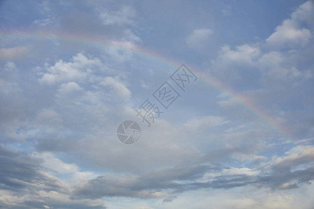 蓝天背景和白云上的彩虹图片