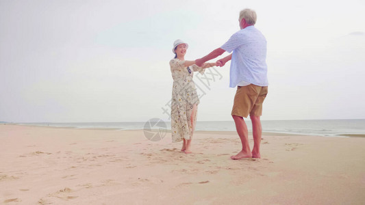 幸福的情侣在沙滩上站在一起手牵手图片