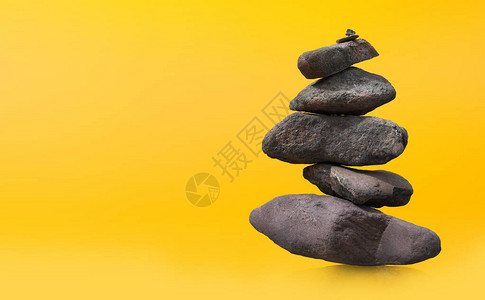 堆石头或岩石与黄色背景平衡图片
