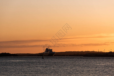一艘货船在日落时的剪影图片