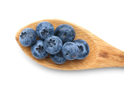 白色背景勺子里的美味成熟蓝莓图片