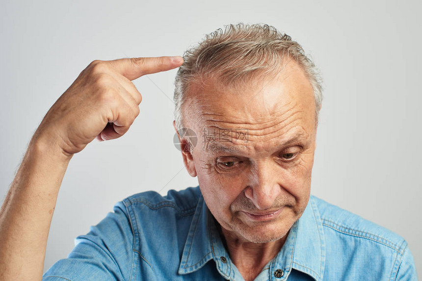 头发问题养老金领取者用一根手指着白发老人秃顶了在蓝色衬衫图片