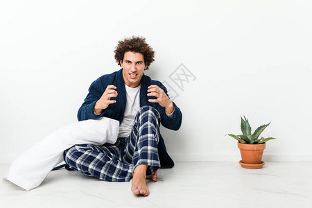 身着睡衣的成熟男子坐在房子地板上心烦意图片