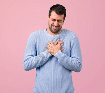 穿蓝色毛衣的男人心脏有疼痛症粉红色背图片
