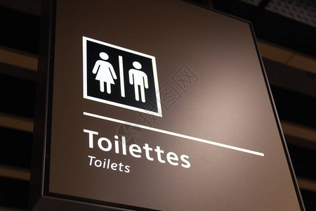 大楼机场车站内蓝盘方向标志和导航指针WC洗手间上的男女图片