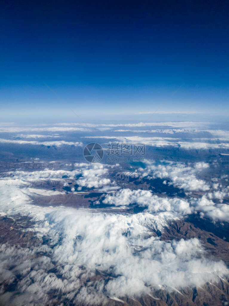 鸟儿对高山顶上满是雪的云层的观视呈现图片